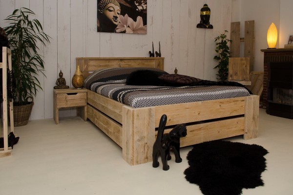 Een eenpersoons steigerhout bed op een slaapkamer